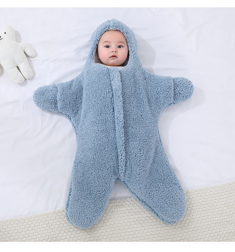 Bébé-combinaison-étoile-de-mer-bleu avec ses mains en vue 