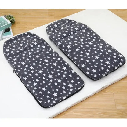 Chanceliere-bebe-Etoile-gris-pose sur matelas On voit le dessus rembourré (appuie-tête) et la forme allongée qui sert à garder un bébé au chaud dans une poussette.