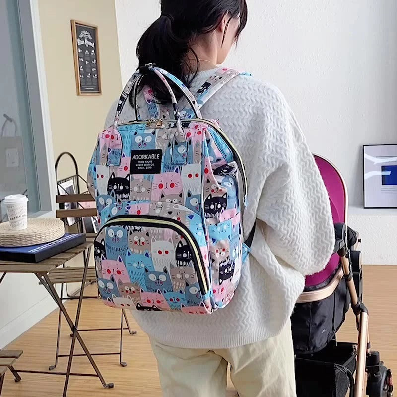 sac a dos a langer sur le dos  d'une maman avec poussette 